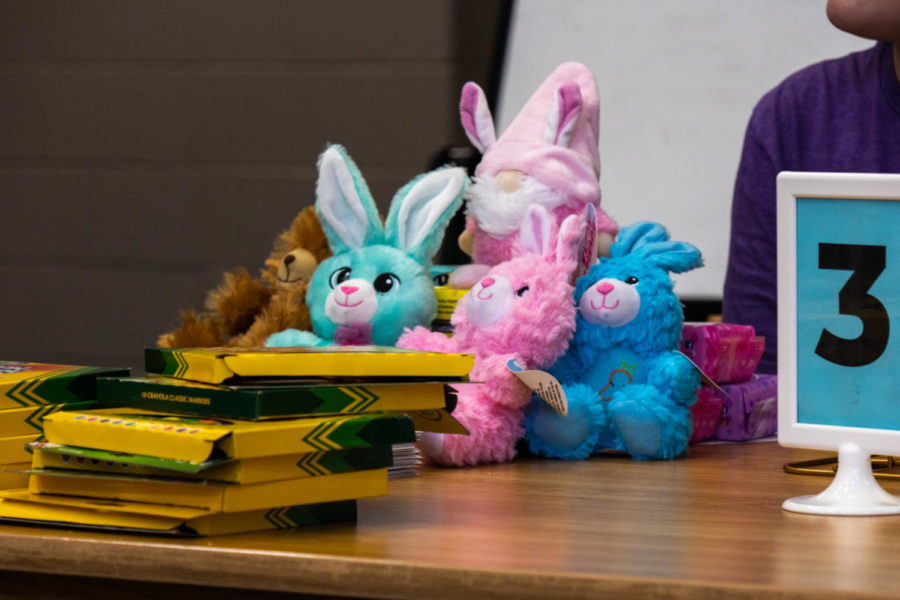 The vibrant pile of stuffed animals sits on the table of prizes waiting for an owner. 