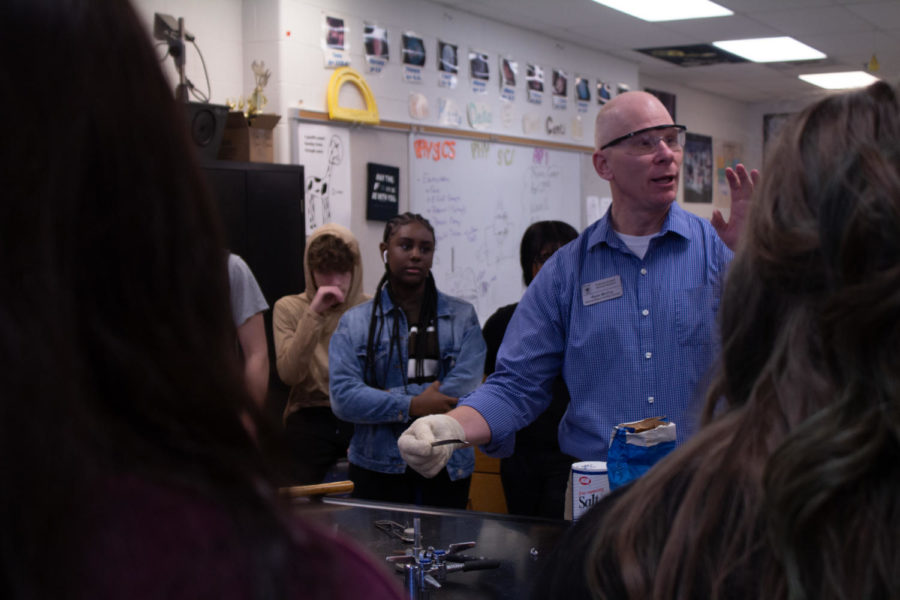 Mr.+McCoy+demonstrating+and+explaining+a+chemical+reaction+while+his+students+watch.