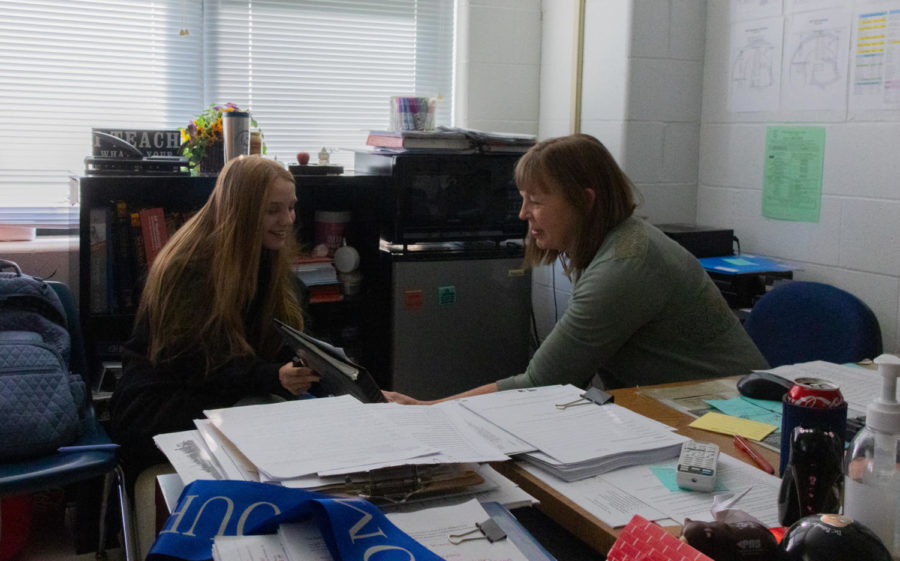 Mrs. Stacy Dennigmann consults with a student on a piece of work in her AP Psychology class.