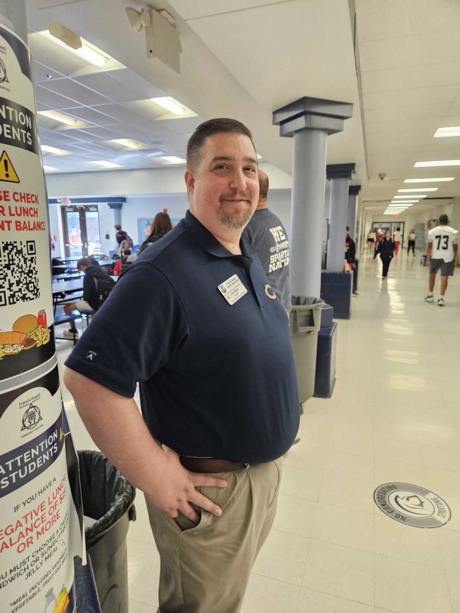 Guidance Counselor Kris Miller smiles at the camera as he supervises students entering into 4A lunch. He and many other staff have started taking up new responsibilities around the school.