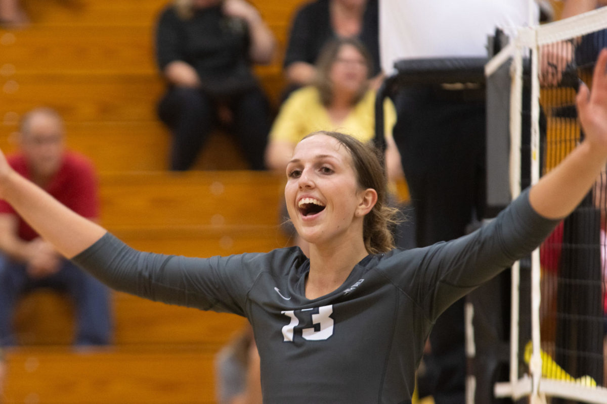 Junior Jordan Smith widely opens her arms in celebration. The volleyball team went on to win each one of their sets. 