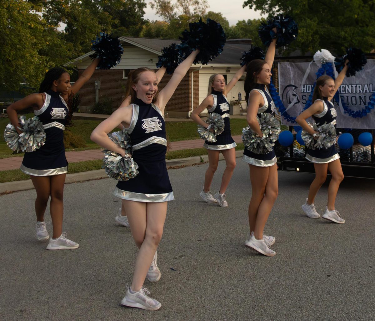 The FHC cheerleaders perform a cheer for viewers on the sidewalk.