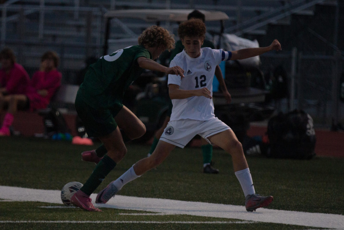 Senior Zach Morris goes to kick the ball away from Timberland and towards his team. 