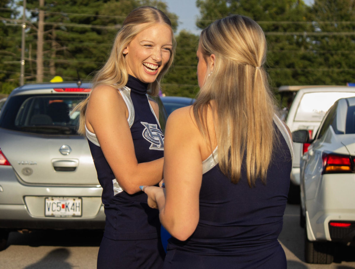 Senior Sensation captain Sam Hantack laughs while talking with her teammate. Hantack was getting ready to walk with the Sensation in the homecoming parade for the last time.