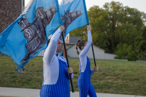 Emily Tobin holds up a flag while walking with the rest of the Color Guard. 