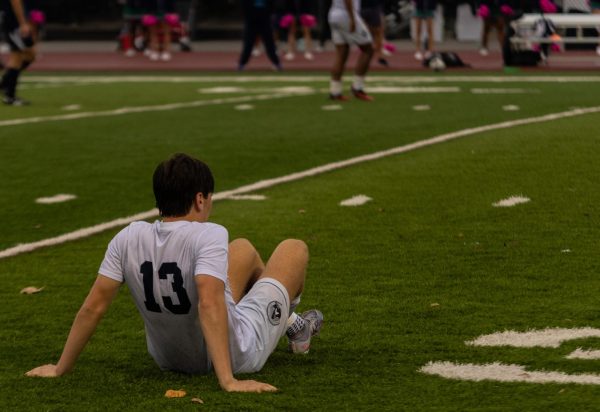 Junior Josh Stuhlman sits on the ground as he waits for the referees to call a penalty after an injury. He had been running against an opposing team member during the game against Marquette on Oct. 25 when he fell over after he had been tripped.