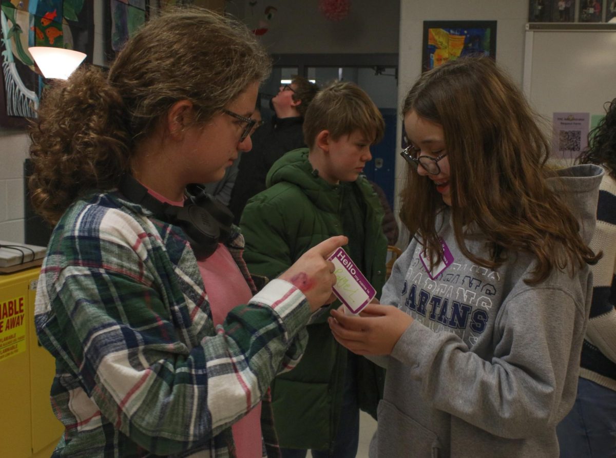 The middle school students are putting on their specially made name tags.