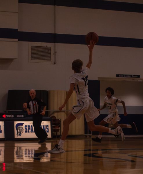 Freshman Charlie Renken jumps up as he reaches for the basketball after a throw-in by one of his teammates. The Spartan boys worked hard and earned another win by 55-33 against the Fort Zumwalt West Jaguars on Dec. 14.