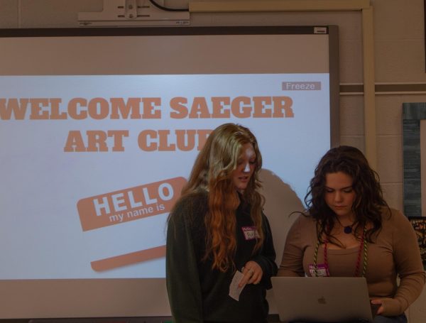 President Layni Murray and Vice President Aubrey Simpson look over the presentation about the art clubs.  This event was to introduce the Saeger middle schoolers to the art aspects of Francis Howell Central. 