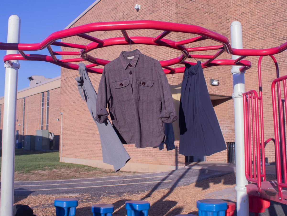 On the playground of Fairmount Elementary, clothes hanging on the monkey bars sway slowly in the wind.