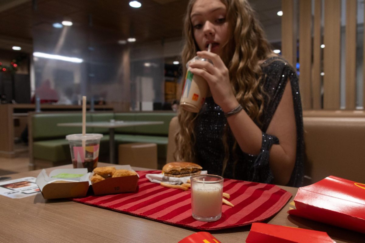As she sits in the McDonalds lobby with a homecoming dress on, middle schooler Korrinne Lay takes a sip of her caramel frappe. I wanted to set the scene with a fancy placemat and candle in order to give the feel that we were at a fancy restaurant rather than McDonalds. 
