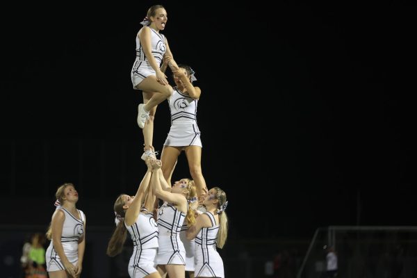 Sophomore Bella Brown is lifted into the air by her teammates. This stunt took the cheerleaders a full week to learn, as it is a difficult stunt typically seen on elite co-ed teams due to the strength and balance required. 
