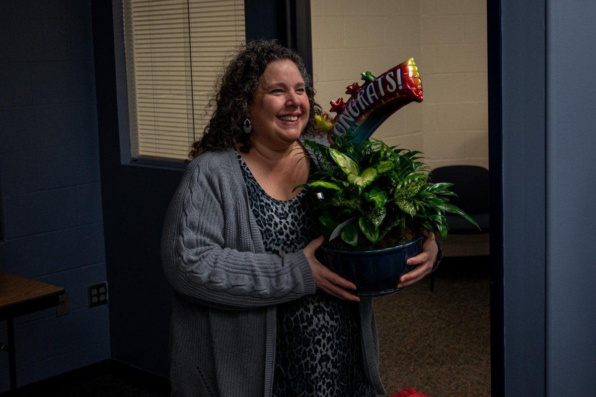 Ms. Wegener smiles as she poses with the flowers she received for her Support Staff of the Year award. 