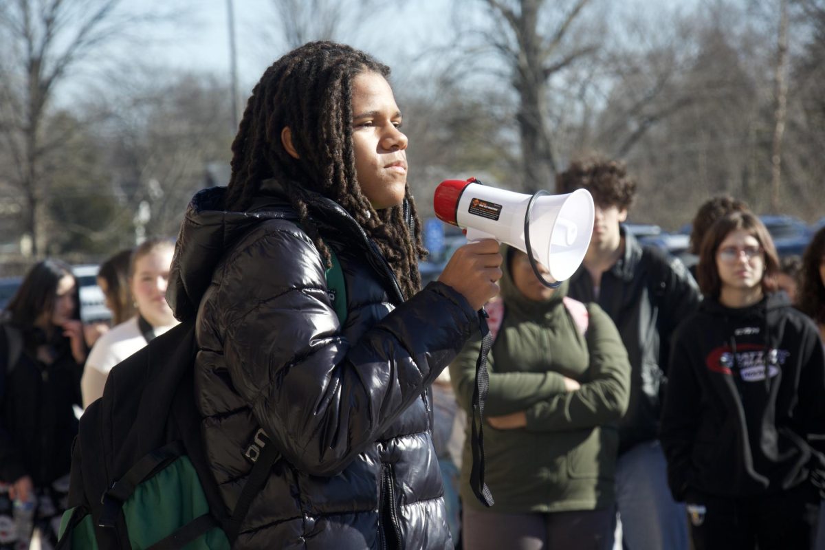 FHC student Avontae Norman holds a microphone with a gloomy look after speaking while watching the collective student body stand in support of the speaker and in protest against the Boards decision.