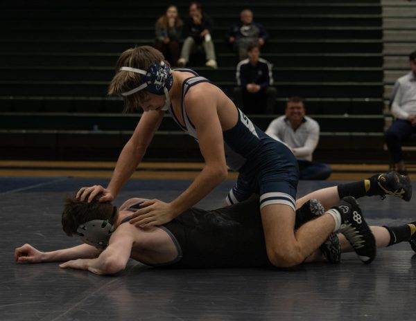 During the match sophomore Chase Gray pushes his opponents head down as he has control. He is doing this in orders to win his match and score points for the Spartans. 