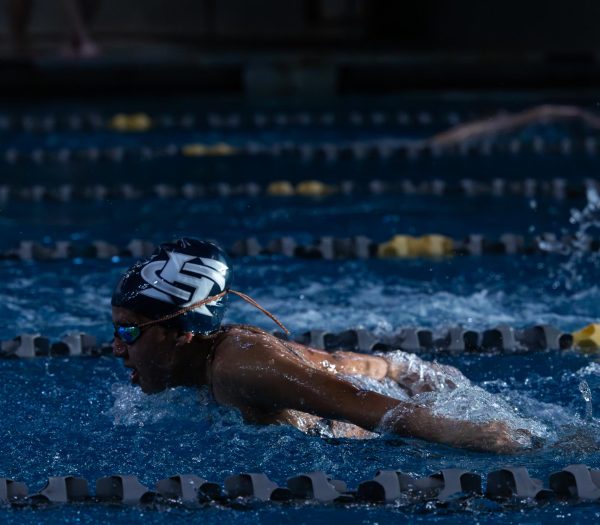 Junior Regina Avila rises out of the water so that she can build up her power while swimming the butterfly stroke. 