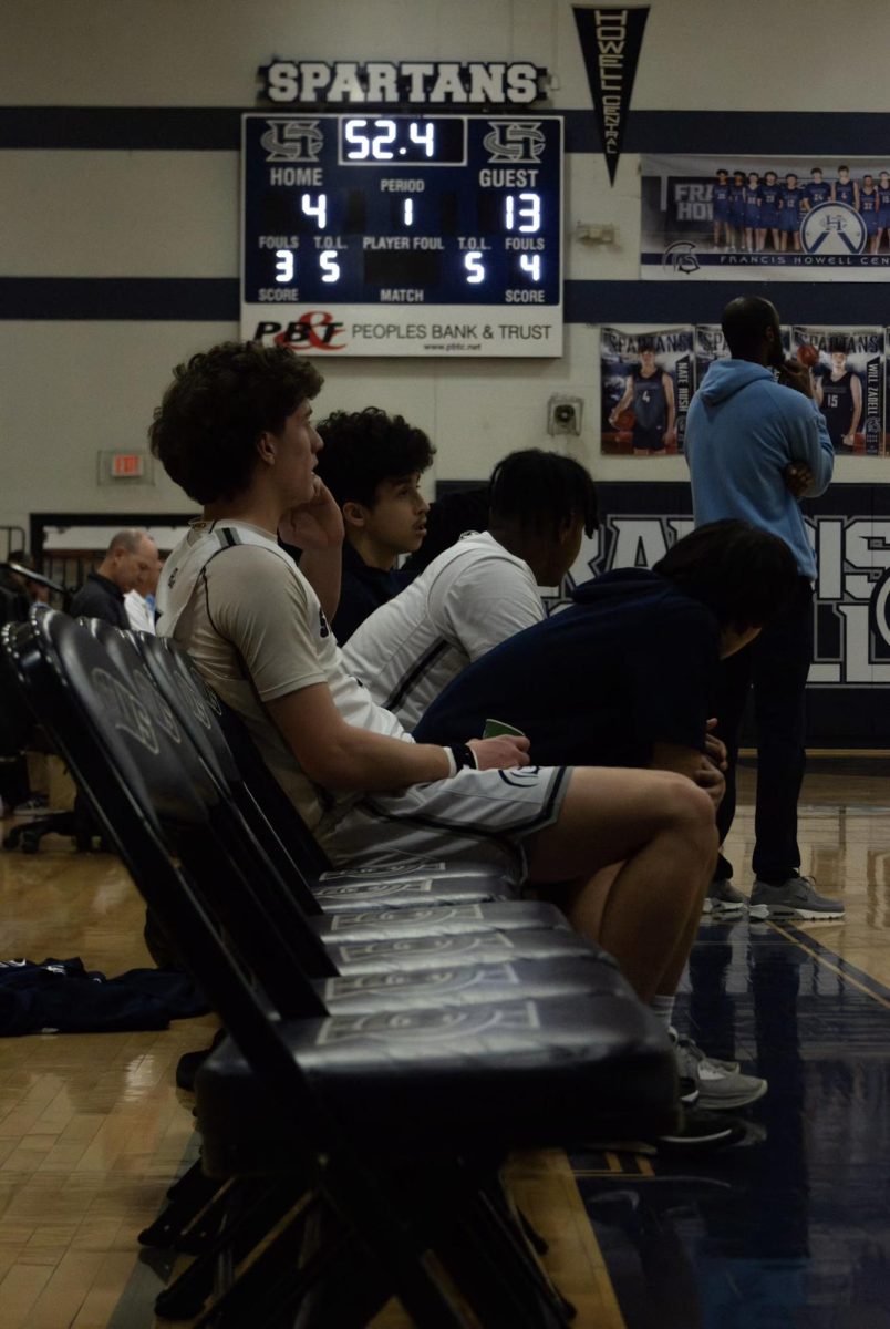 On the bench intently watching his team play is Cooper DeManuele.