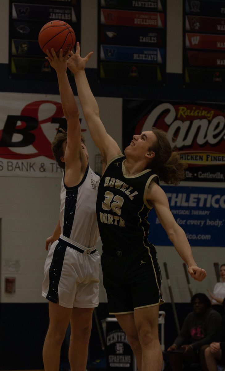 On March 13, senior Nate Rush jumps for the ball during the tip-off during the senior night game. 
