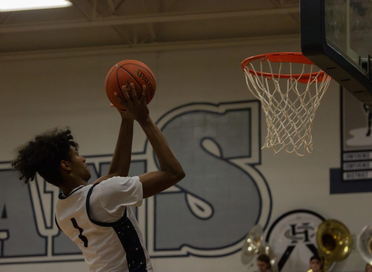 During the March 13 senior night game, sophomore Xavier Morrison gets closer to the basket to make a layup for some extra points.