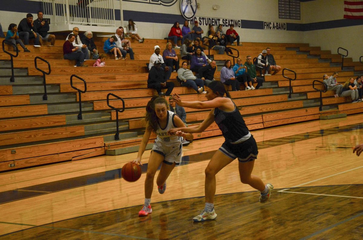 Pushing forward, Junior Reese McDevitt drives past her opponent towards the basket.