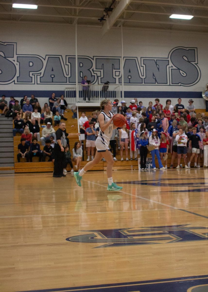 Riley Henderson races down the court with the ball.