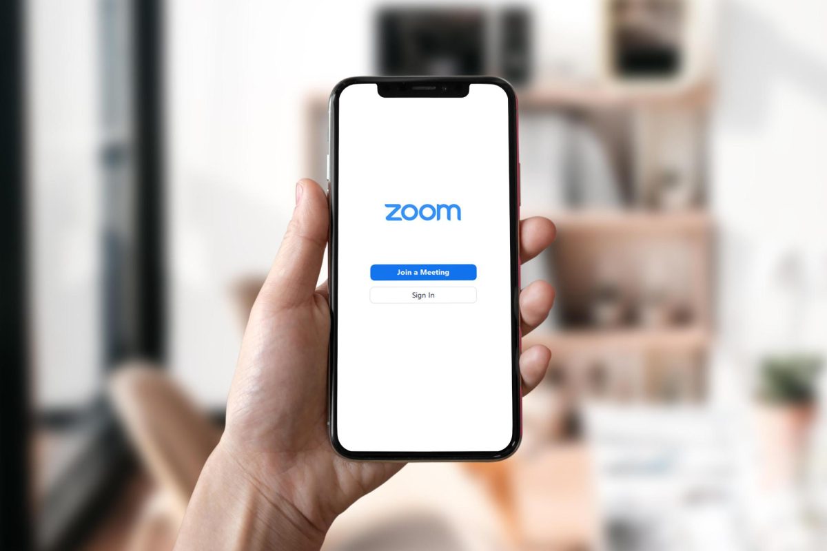 A person holding up their phone while using the Zoom application the world has become familiar with after COVID-19. Clubs such as the Speech and  Debate team continued to have meetings through zoom during the AMI days. 