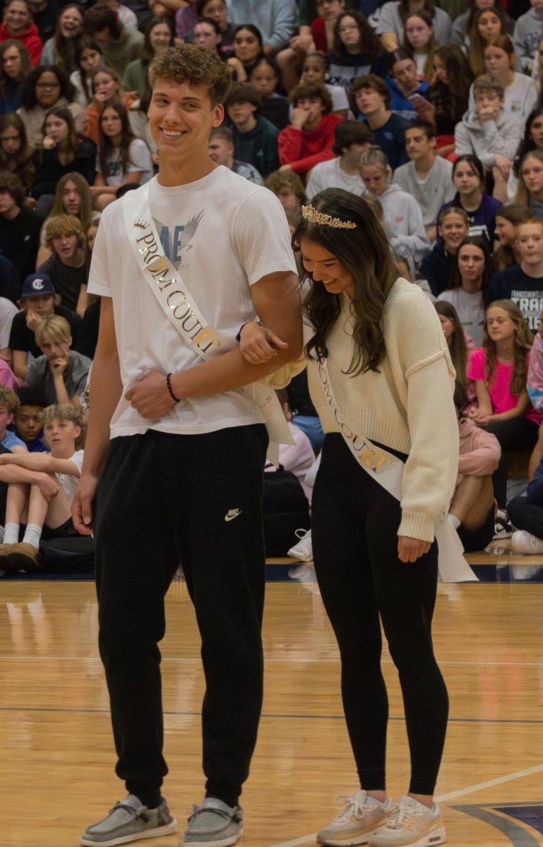 Seniors Joshua Hayes and Ally Brower laugh together as they go out into the middle of the gym to be recognized for being on prom court at the spring pep assembly on April 11. 

