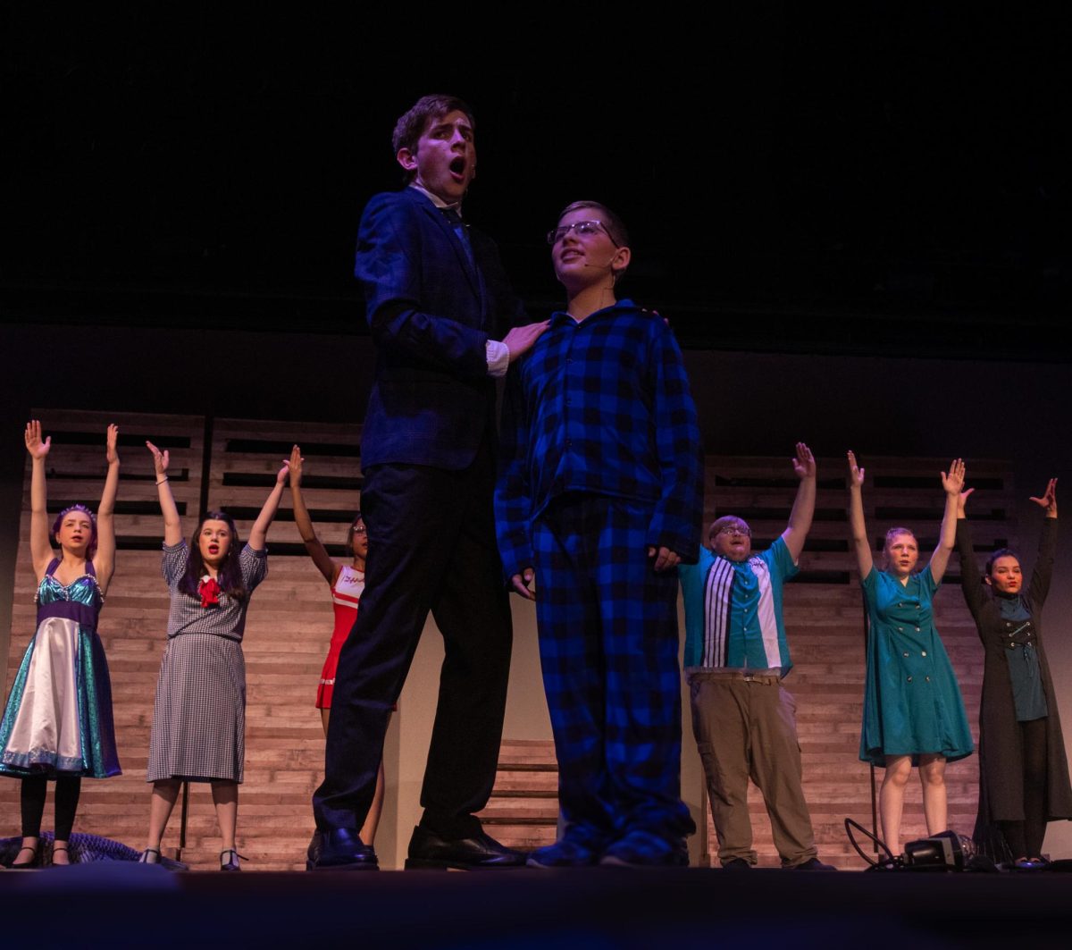 At the end of the opening scene of “Big Fish”, junior Connor Becker and middle school student Kyle Baumann, stand under the glowing lights. The cast stands behind in the final pose of the song. 
