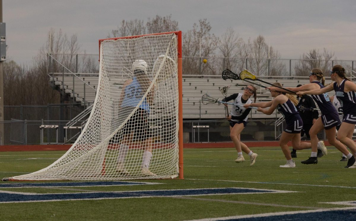 Reaching to score a goal is freshman Addison Holtgrewe with the opposing team striving to stop her. Holtgrewe made the goal despite the tough circumstances.
