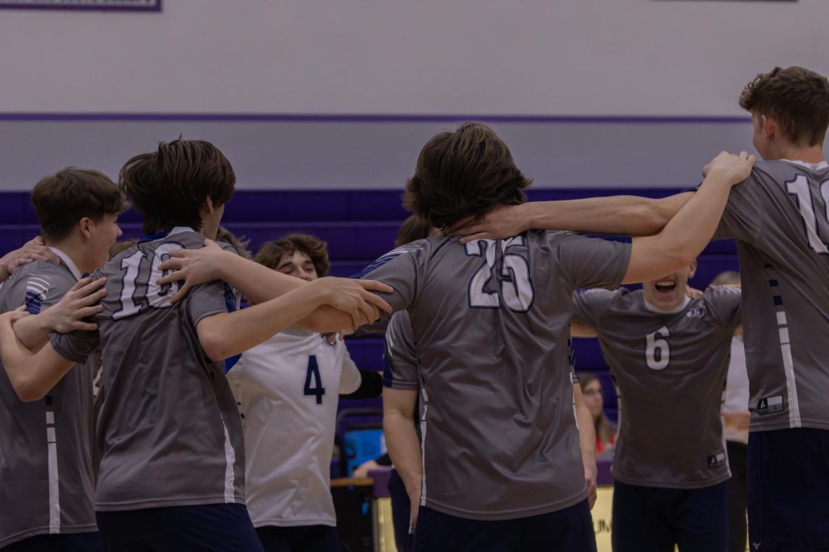 The boys’ varsity volleyball team huddles up before the game on April 4 against Fort Zumwalt West. Senior Liam Stover does a backflip in the middle of the team huddle as a way to hype everyone up for the game.