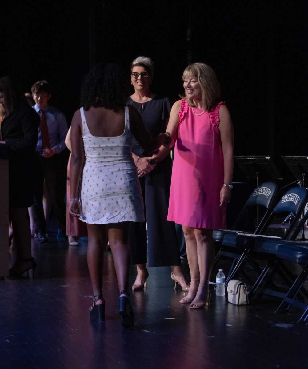 Sophomore Liya Fikru stops to shake hands with Mrs. Odle before officially becoming an NHS member. 
