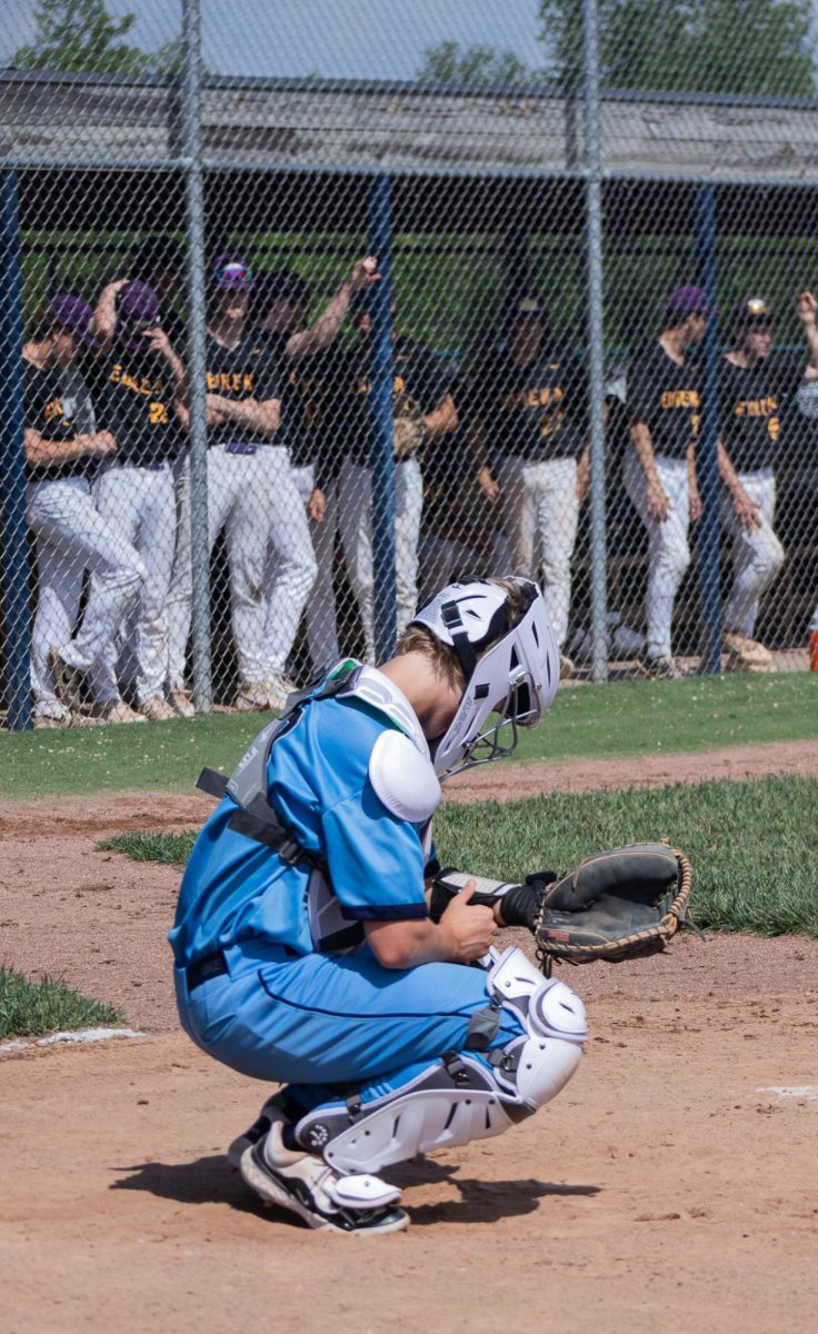 During the Varsity vs. Eureka game on May 4 senior Gabe Duncan looks down at his arm to tell the pitcher what play to run.
