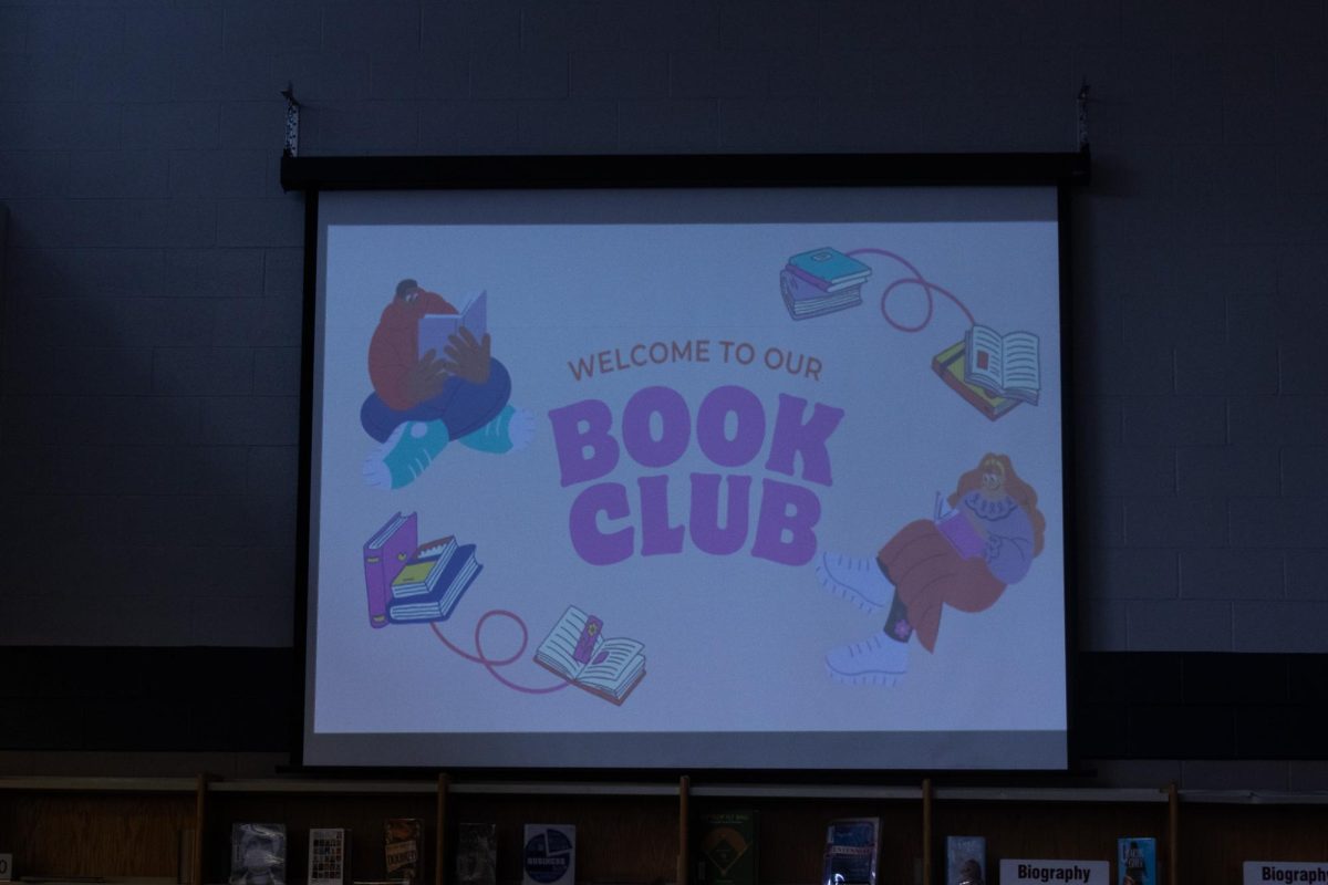 A welcoming sign is projected onto the screen as students enter the library. The event was led by Mrs. Tonishia LaMartina with special guest and author Johnathan Shoff. 