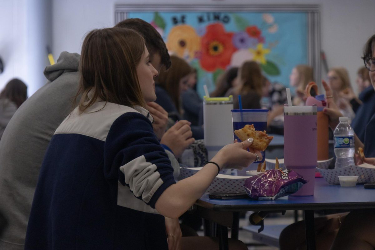 Isabella Wheeler talks with her friends over her school lunch.
