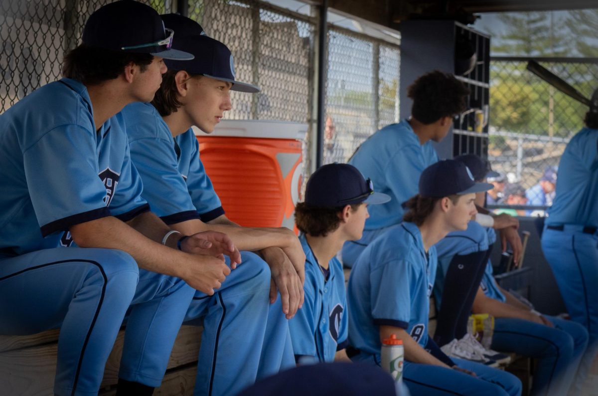 The boys varsity baseball team sits in the dugout and watches their teammates play on the field during the Central vs Eureka game on May 4.