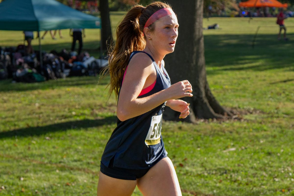 Reese McDevitt looks at the course ahead during a cross country race. McDevitt set a school record of 19:16.7 this year to become the fastest female junior in school history. 