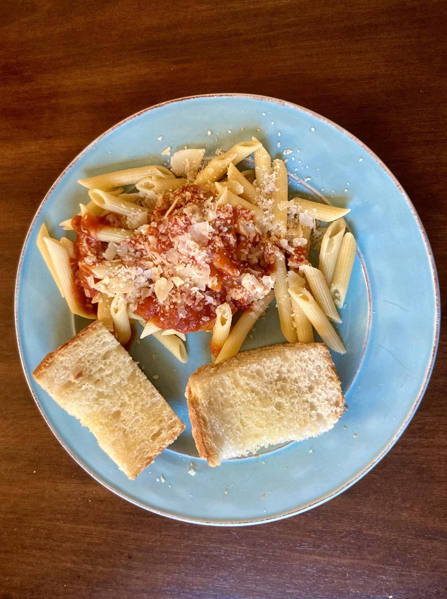 Penne pasta with tomato sauce and garlic bread.