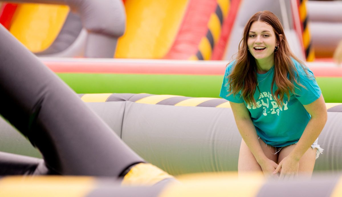 Member of Arete laughs while waiting while the inflatable bar comes towards her.