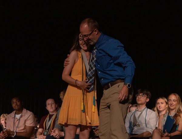 College counselor Dustin Bailey and senior Laney Parmeley hug after she is chosen for the family and consumer science departmental award. She received this honor for her dedication to the many developmental classes, at the Senior Award ceremony on May 9. 