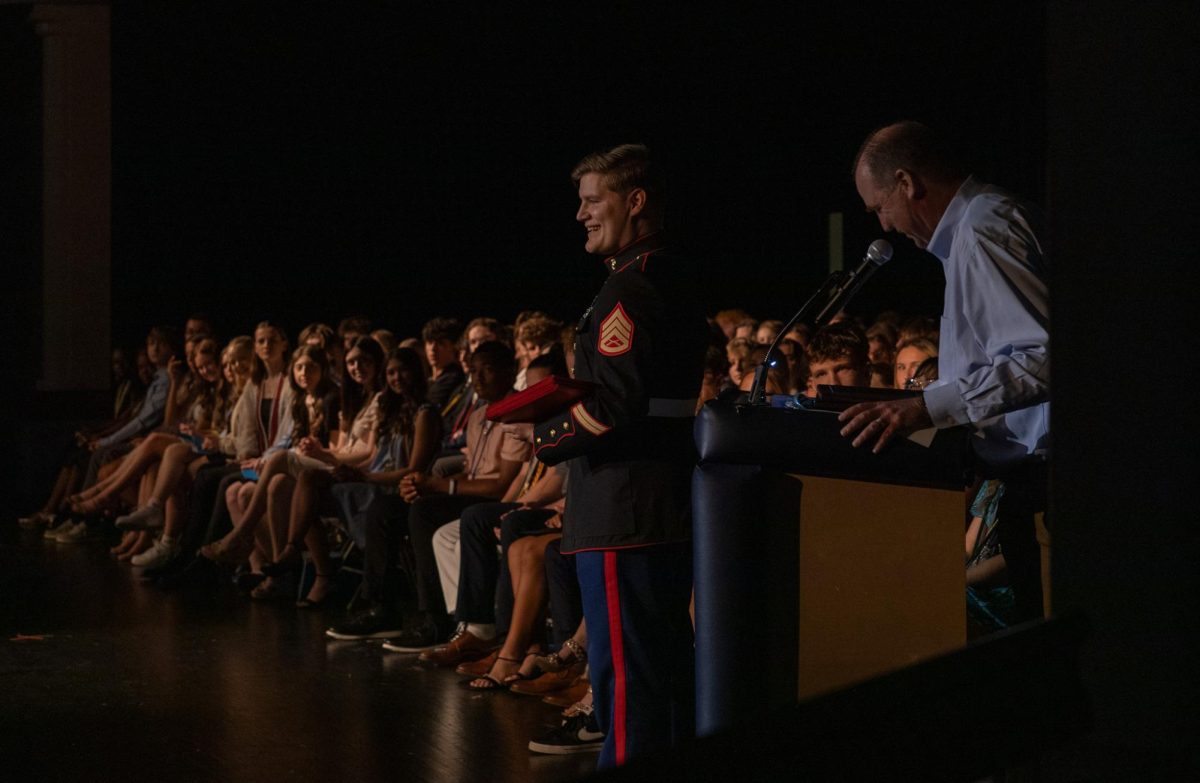 Coach Scott Harris reads out the winners of each Presidential Educational Excellence award while Marines Sergeant Joshua Miles stands to the side and waits to hand out each award.