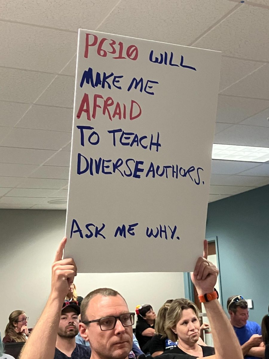 English+teacher+Dr.+Jason+Becker+holding+a+sign+reading%2C+P6310+will+make+me+afraid+to+teach+diverse+authors.+Ask+me+why.+The+policy+will+remove+many+books+out+of+the+district+Learning+Commons+and+the+process+to+gain+approval+for+specific+titles+will+be+slow+and+smaller+scale+than+demand+by+librarians+and+students.