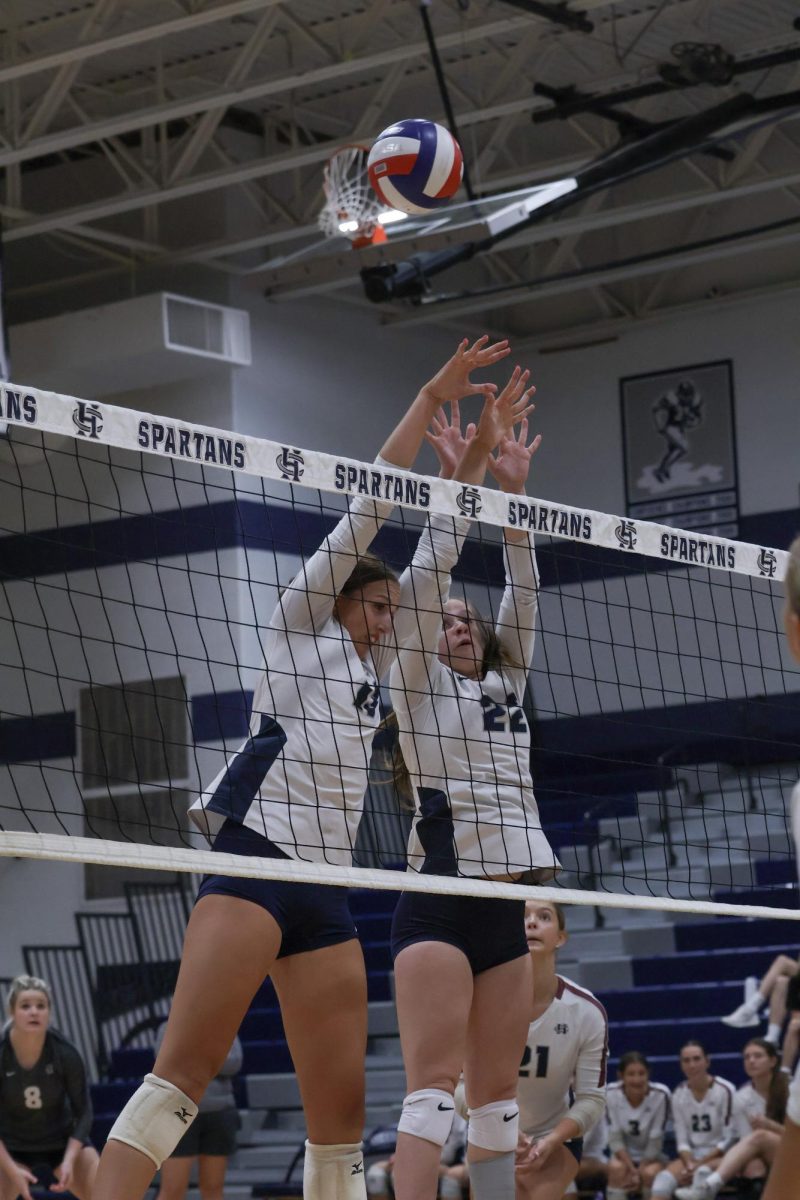 Seniors Jordan Smith and Ava Jundt jump to try and block the hit from the opposing team. Blocking, a major aspect of volleyball, can be done by multiple people in order for it to be more successful.