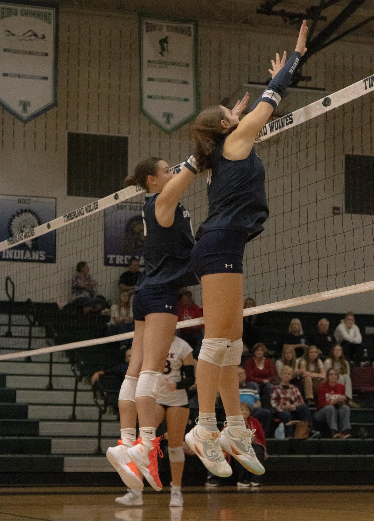 Outside hitter sophomore Ava Schutte jumped up to block a ball from the opposing team.  She jumped up with her teammate to try and prevent a point.
