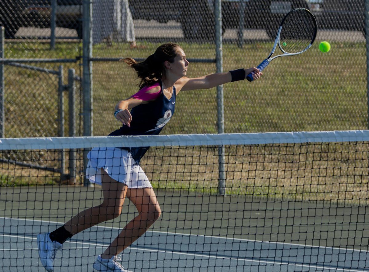 Junior Molly Kate Morris reaches her body across the court to try and reach the ball in time to hit it back. Morris reached the ball in time, but was unsuccessful in hitting it over the net. 