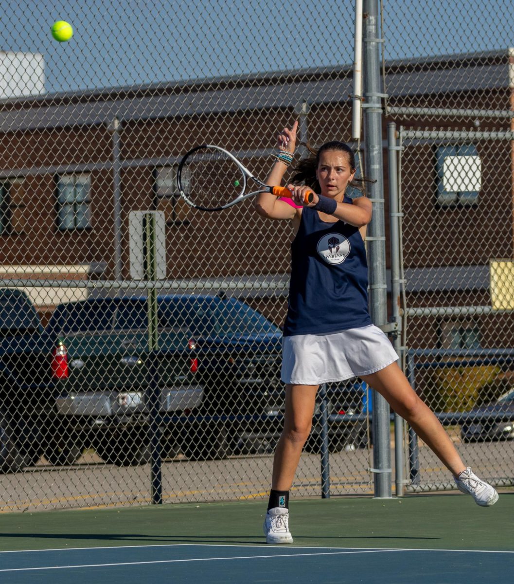 Receiving the serve, Molly Kate Morris holds up her finger as she hits the ball back. This signals to the other person that the serve was out of bounds.  