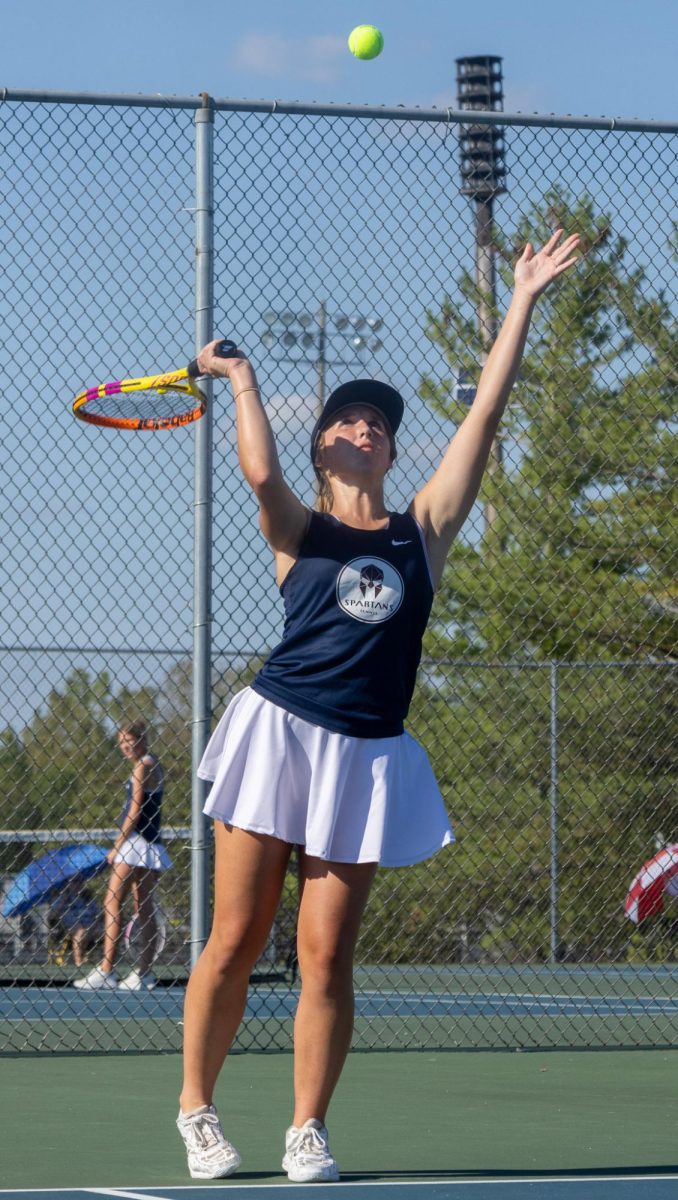 Junior Kyleigh Harmon strikes the ball, making it slice through the air.  The two teams volleyed back and forth before Helias took the point. 