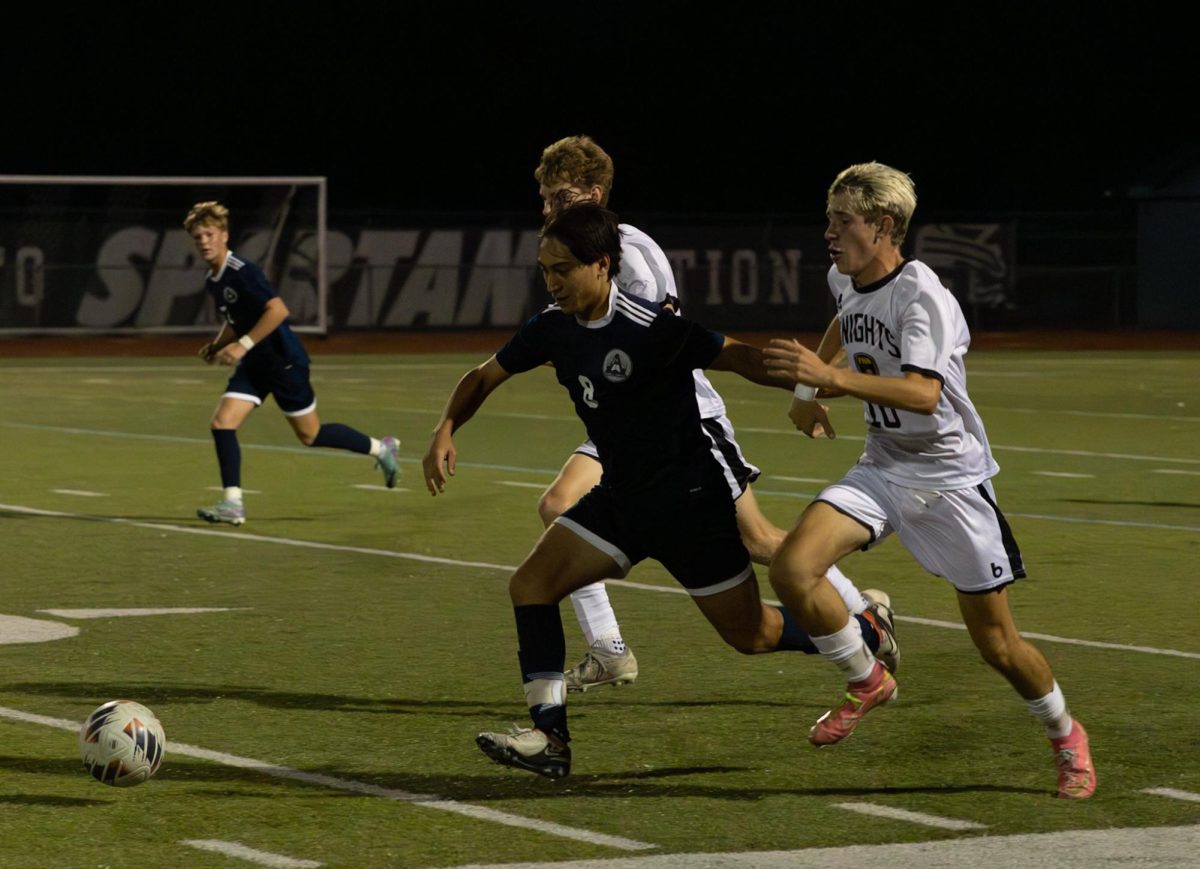 At the game against Francis Howell North on Sept. 10, sophomore Arjen Lopez runs to get up to the ball in front of him. He had two defenders on him attempting to stop him from getting the ball to pass to his teammates. 
