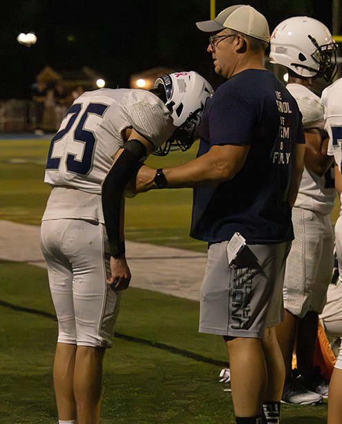 Head coach Don Lober firmly holds Will Bradley's jersey. Bradley had received an incomplete pass, not being able to catch the ball and secure the pass, Bradley felt he had disappointed the team. 