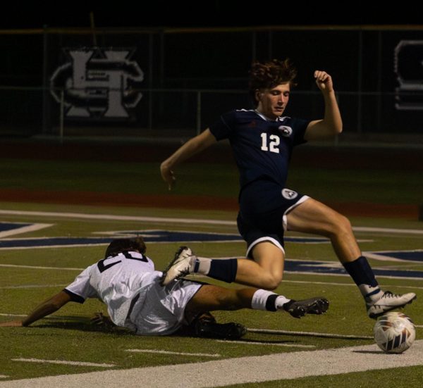 Senior Josh Stuhlman dodges the player attempting to slide and kick the ball at the game against Francis Howell North. While dodging the player Stuhlman also kicked the ball to a teammate nearby on Sept. 10.
