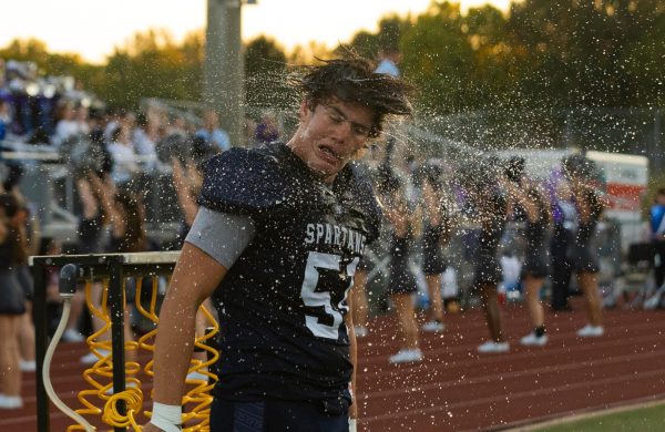 Senior Landen Mouser shakes the water from his hair and face after dousing himself in water with the pick. During the game against Festus high school on Sep. 6, Mouser’s hard work helped play a key role in the Spartan’s first quarter touchdown.  